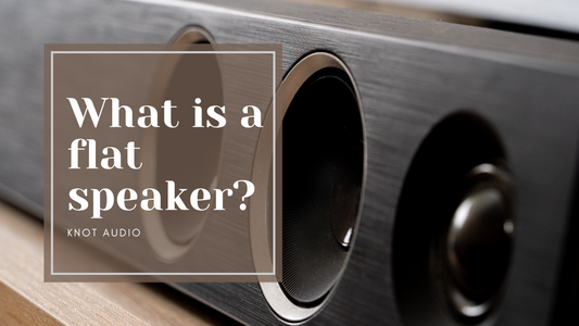What is a flat speaker? Knot Audio. Soundbar in the background made of wood.